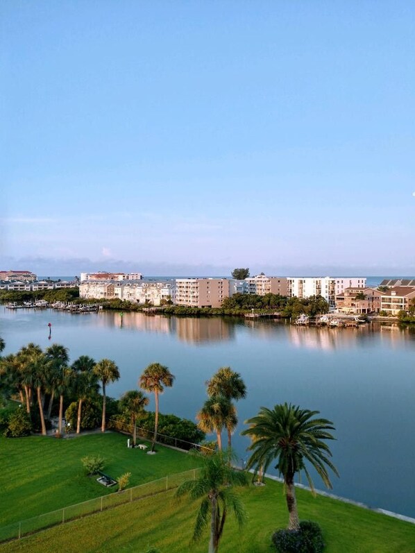 A waterfront property with a marina, palm trees, and a row of multi-story buildings.