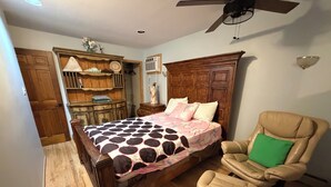 A bedroom with a wooden bed, a chair, a dresser, and a ceiling fan. - Private Apartment Near UBS Arena &JFK (Elmont)