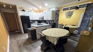 A compact kitchen with a dining area, a refrigerator, a microwave, and a sink. - Private Apartment Near UBS Arena &JFK (Elmont)