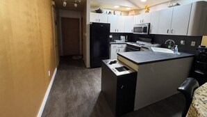 A compact kitchen with a refrigerator, microwave, stove, sink, and cabinets. - Private Apartment Near UBS Arena &JFK (Elmont)