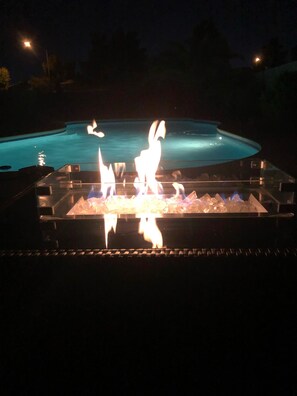 A pool with a fire feature in the foreground. - Charming Private Oasis- Approx 10 min to strip, Arcade Machine,FootMassagers (North Las Vegas)
