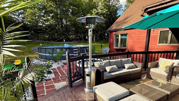 Una terraza con mobiliario exterior, un cubo de basura y una piscina.