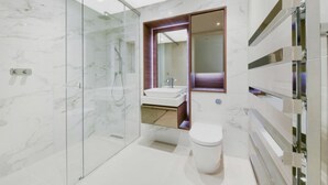 Ein modernes Badezimmer mit einer Duschkabine, einem weißen Waschbecken und einer Toilette.