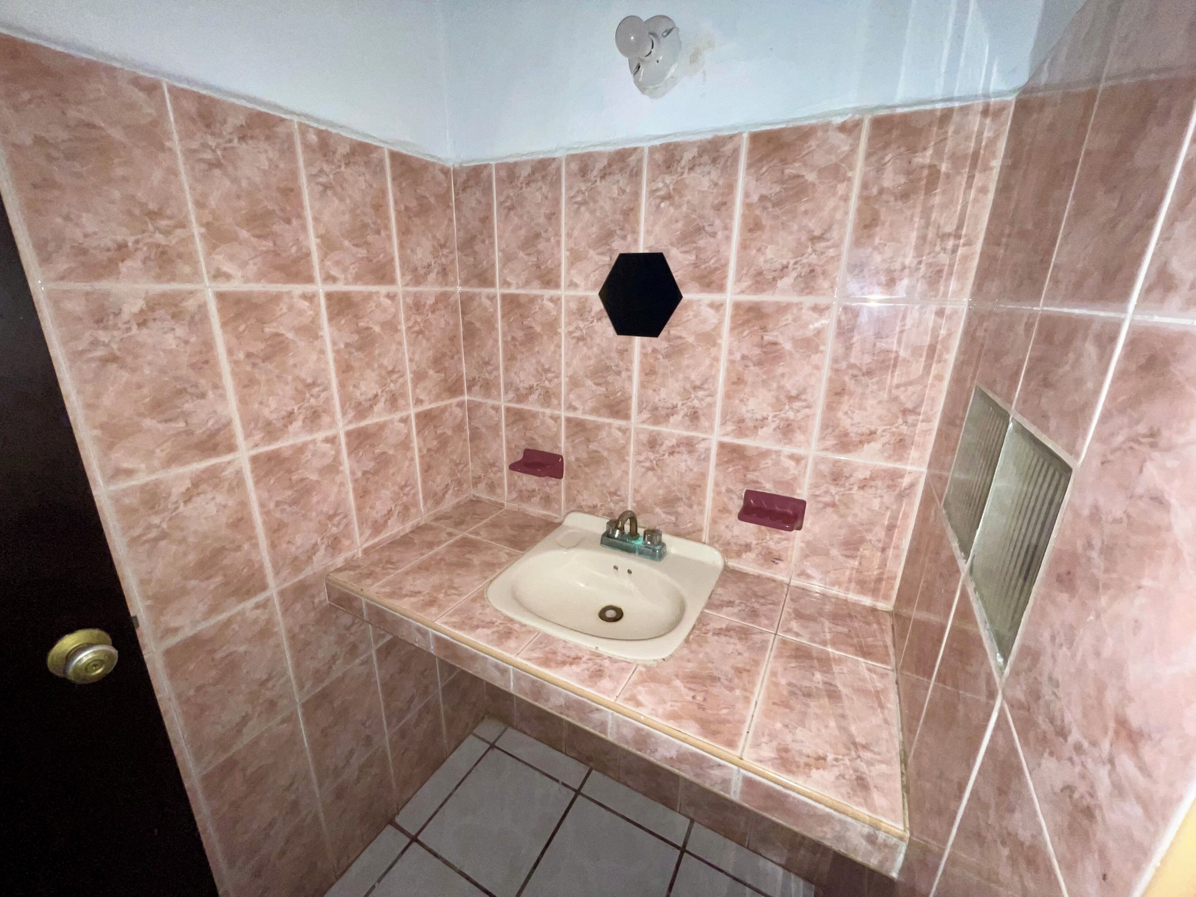 Une salle de bain équipée d’un lavabo, d’un miroir et d’une zone douche.