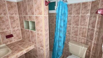 A bathroom with a shower, toilet, and sink.