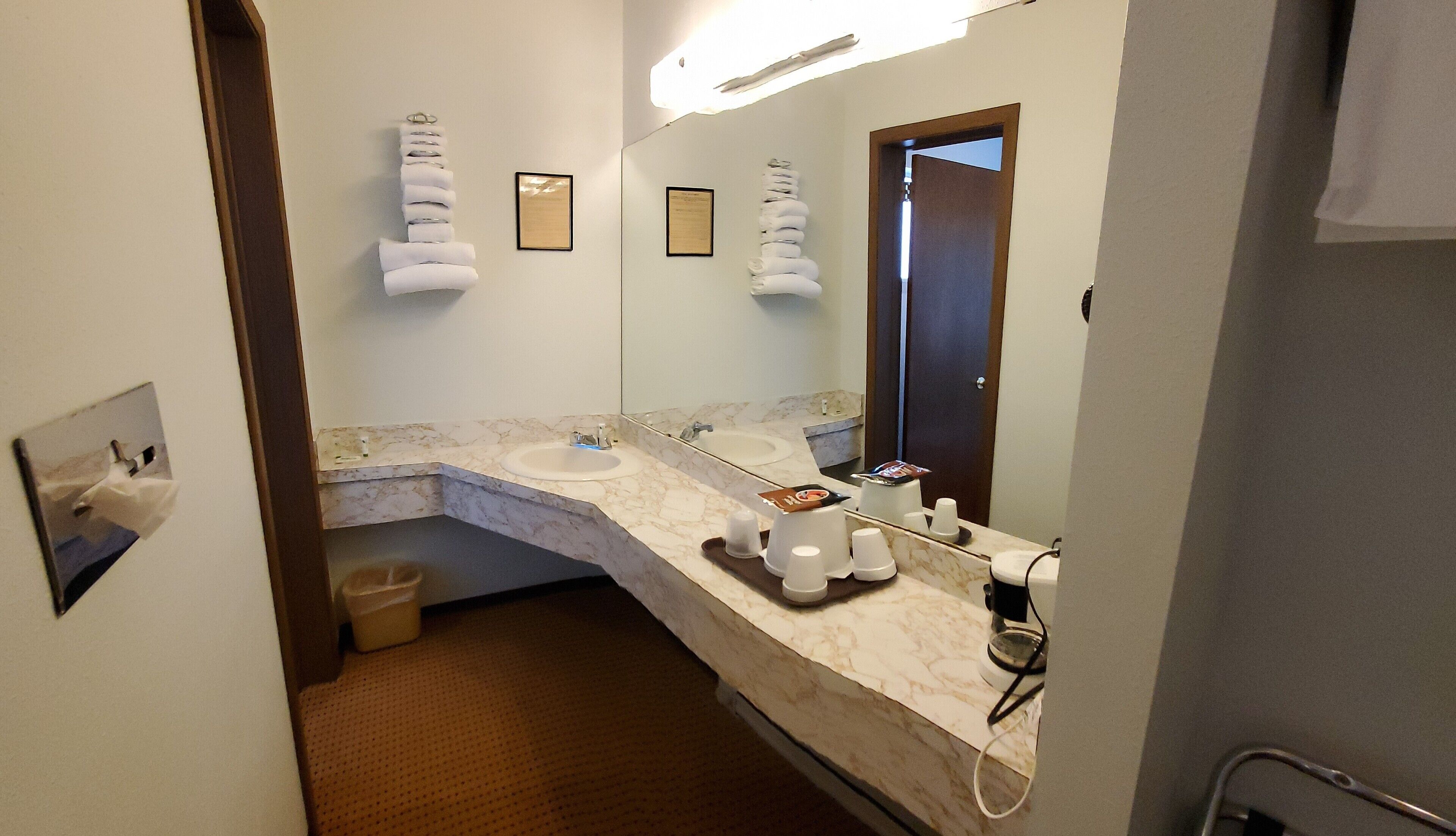 A bathroom with two sinks, a mirror, and a towel rack.