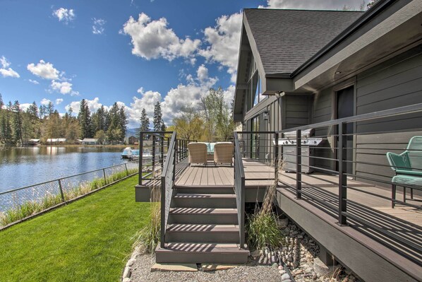 Terraza con mobiliario exterior, una parrilla y vistas al lago.