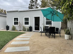 Enjoy al fresco dining in the serene backyard, surrounded by lush greenery and a beautifully manicured lawn.