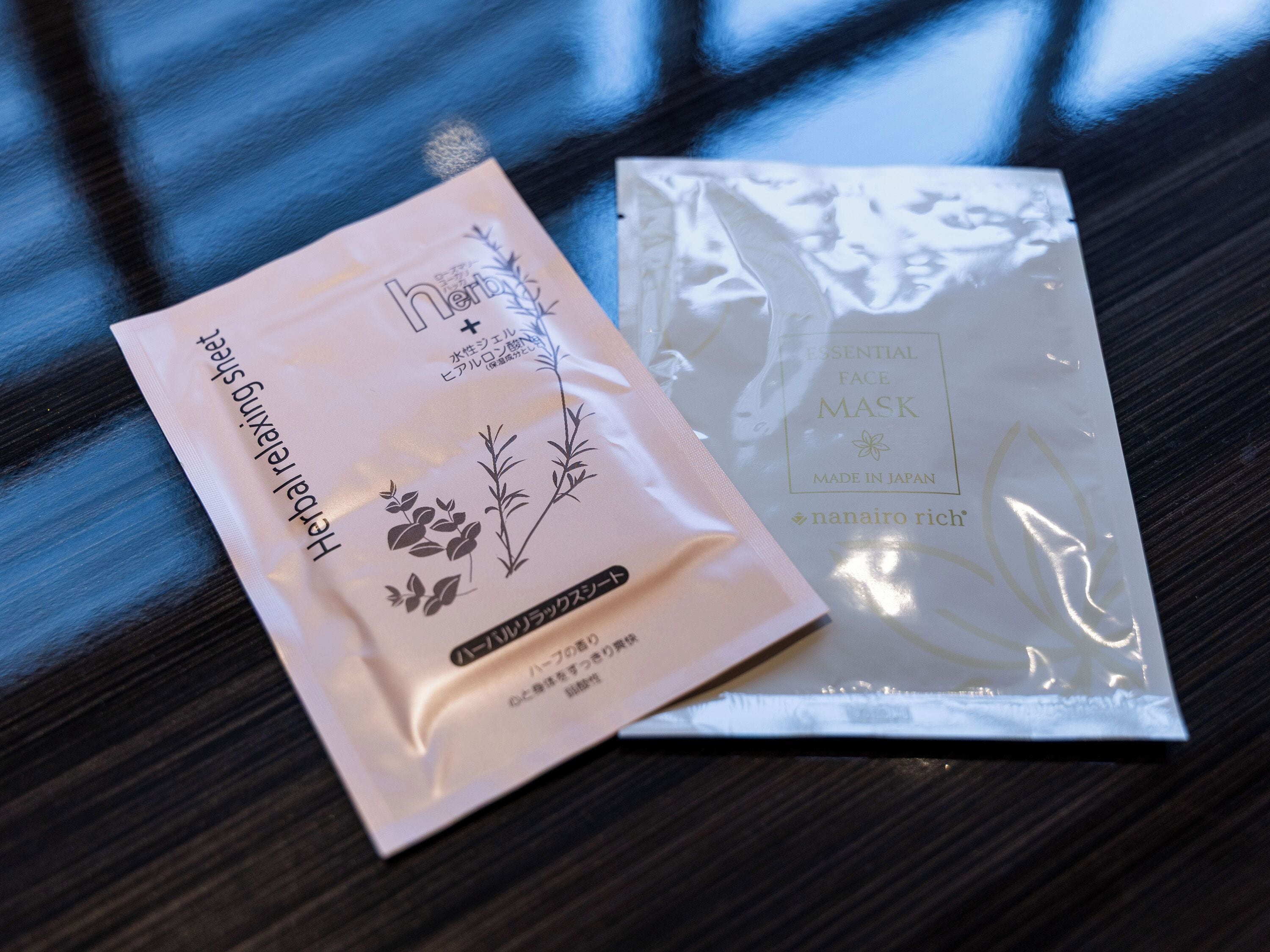 Two cosmetic product packages on a reflective surface.