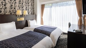 A hotel room with two beds, a desk, and a large window with curtains. - APA Hotel Osaka Kadomashi Ekimae (Kadoma)