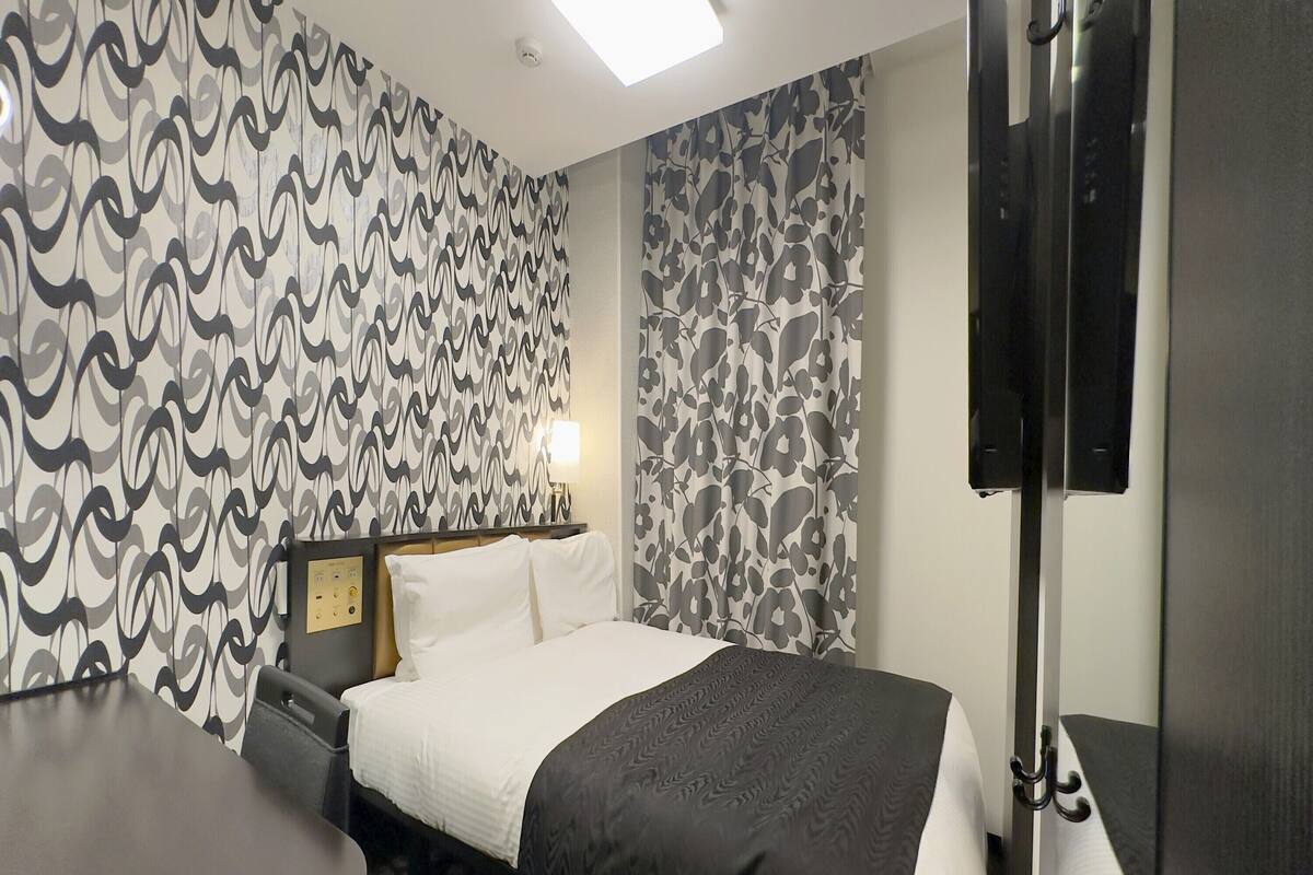 Une chambre d’hôtel avec un lit, un bureau et une télévision.