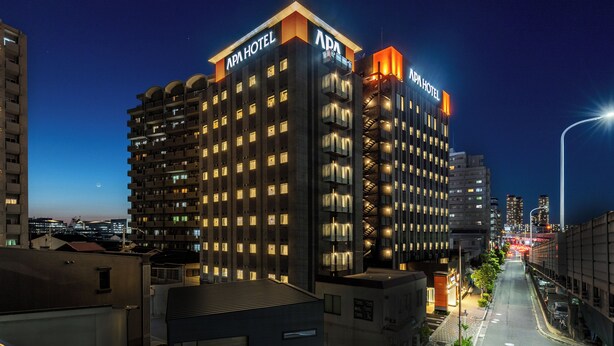 A multi-story hotel with a modern design, featuring illuminated signage and a prominent entrance. - APA Hotel Osaka Kadomashi Ekimae (Kadoma)