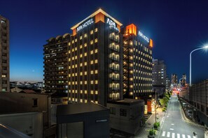 A multi-story hotel with a modern design, featuring illuminated signage and a prominent entrance. - APA Hotel Osaka Kadomashi Ekimae (Kadoma)