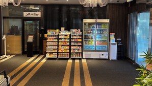 A hotel lobby with a vending machine, snack shelves, and a large chandelier. - APA Hotel Osaka Kadomashi Ekimae (Kadoma)