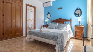 A bedroom with a bed, a wardrobe, a bathroom, and a mirror. - Villa "Manuel" with Mountain View, Sea View, Pool, Terrace & Garden (Nerja)