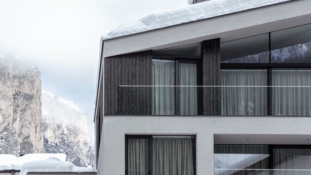 Ein modernes, zweistöckiges Gebäude mit großen Fenstern und einem Balkon.