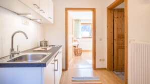 Una cocina moderna con un lavamanos, armarios y vistas a un comedor.