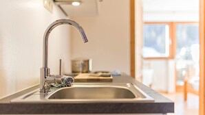 A modern kitchen with a stainless steel sink, a faucet, and a countertop. - Lettnerhof – Family Suite Balcony 5. Surrounded by Nature, South-Facing Balcony, Mountain View, Wi-Fi. (Welsberg)