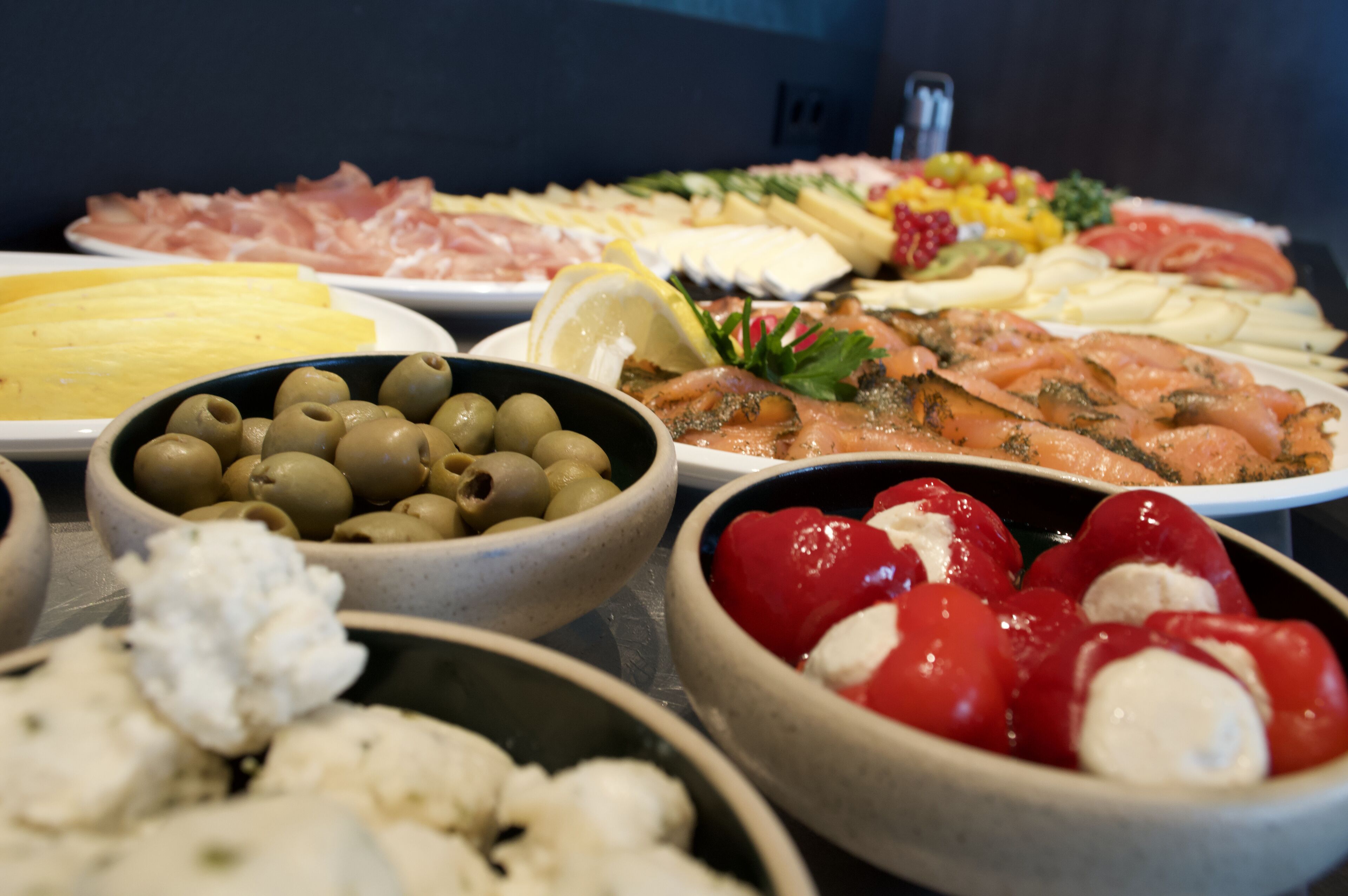 A variety of food items including olives, tomatoes, and cheese on a table.
