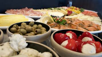 A variety of food items including olives, tomatoes, and cheese on a table.