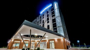 Ein modernes Hotel mit auffälliger Beschilderung, überdachter Eingangspartei und Parkplatz.