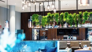 Eine moderne Bar mit Fernseher, Barhocker und einer Auswahl an Flaschen.