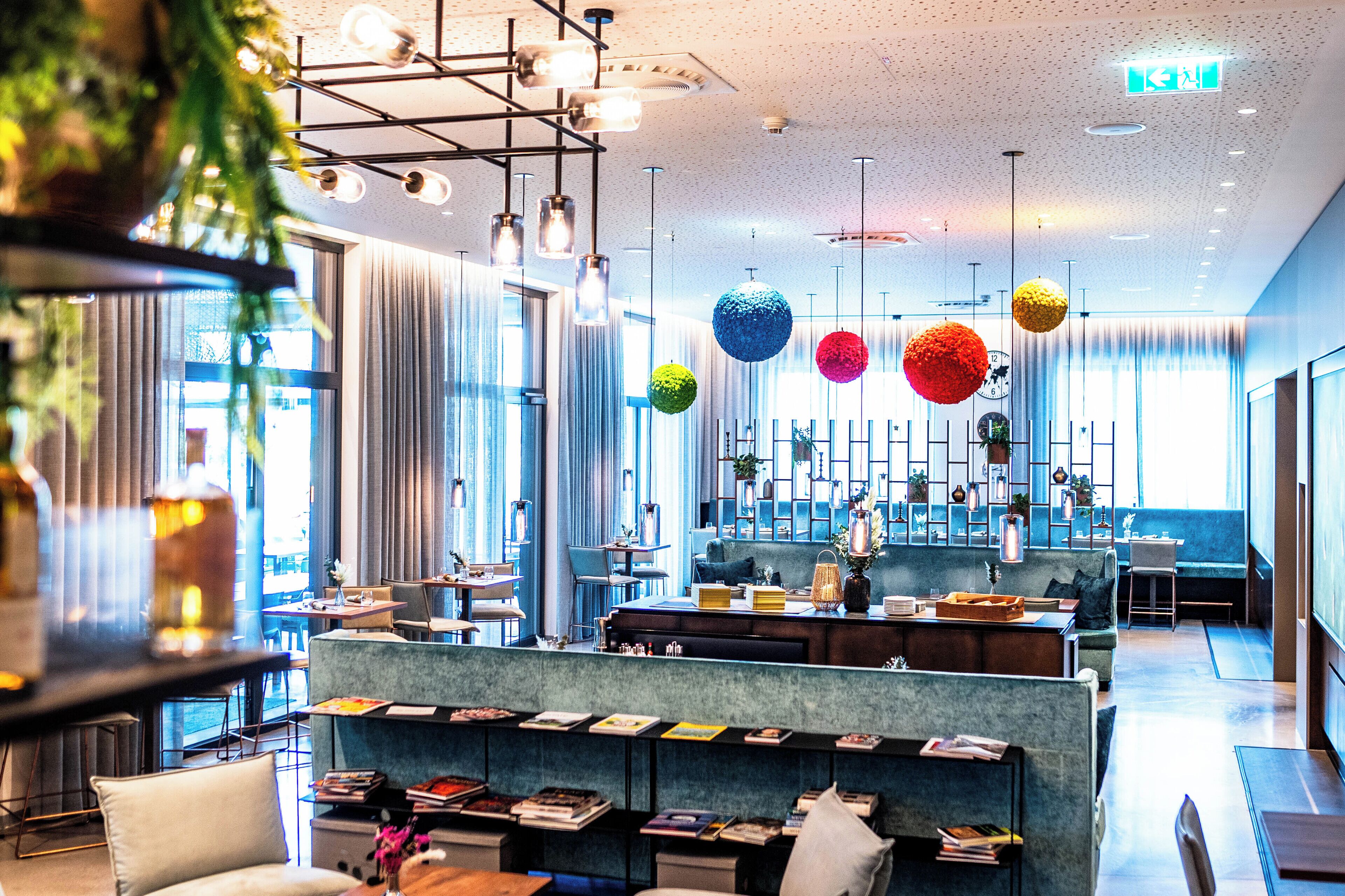 Ein modernes Interieur mit Sitzbereichen, einer Bar und einer Küche im Hintergrund.