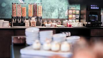 Un área de bufé con diferentes dispensadores de alimentos, una máquina de café y un dispensador de bebidas.