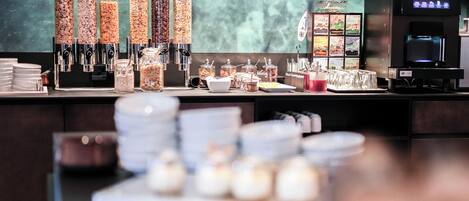 Un espace buffet avec différents distributeurs de nourriture, une machine à café et un distributeur de boissons.