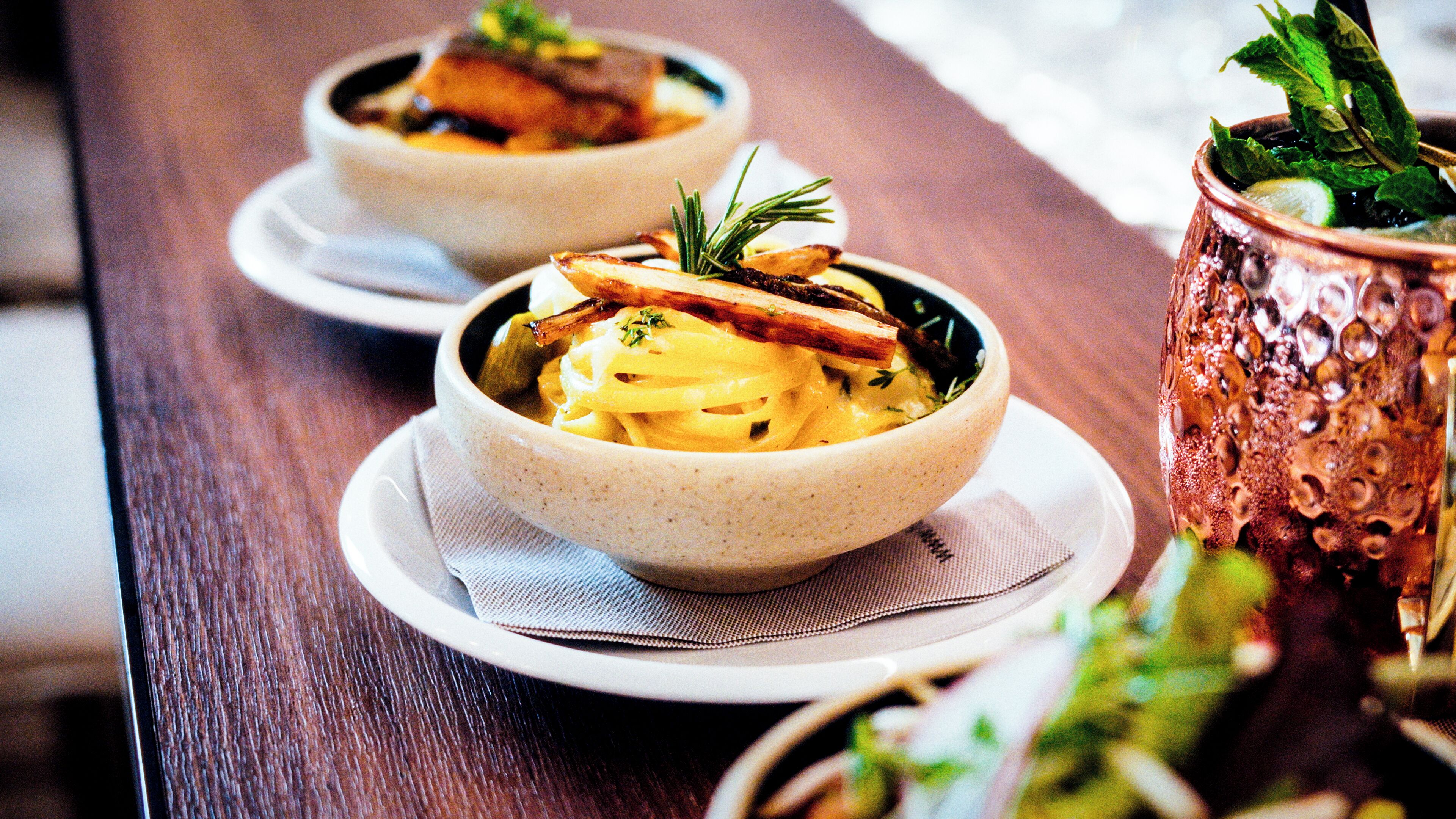 Dos platos de pasta con una decoración en una mesa de madera.