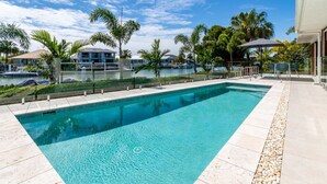 A rectangular swimming pool with clear blue water, surrounded by a tiled deck and a pebble border. - Paradise on the Promontory (BANKSIA BEACH)