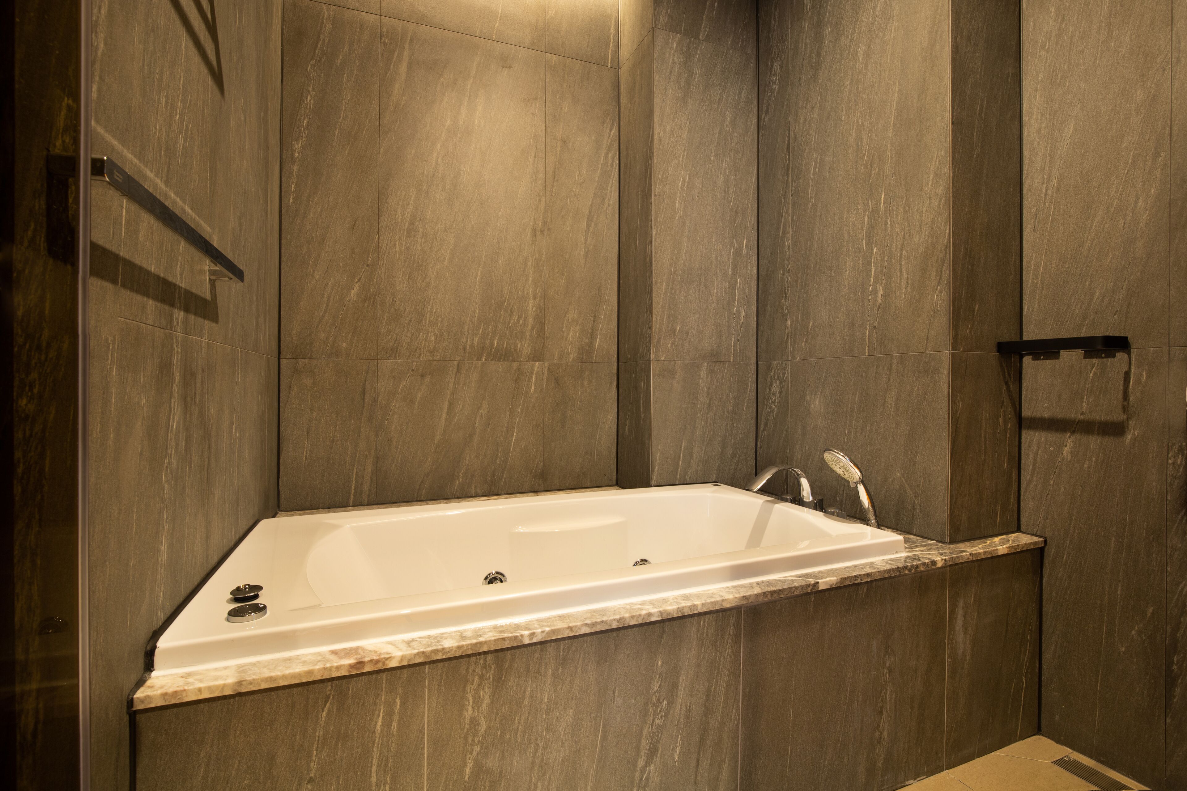 A modern bathroom with a freestanding bathtub, a shower area, and a marble countertop.