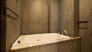 A modern bathroom with a freestanding bathtub, a shower area, and a marble countertop.