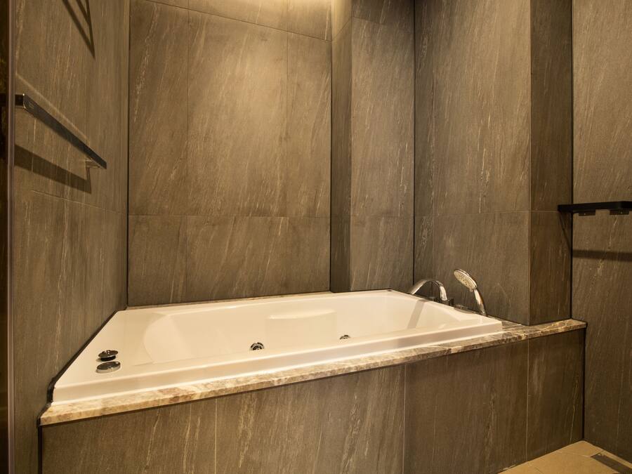 A modern bathroom with a freestanding bathtub, a shower area, and a marble countertop.