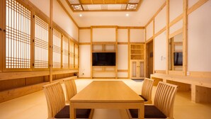 Een traditionele Japanse kamer met tatami vloerbedekking, een lage houten tafel en ingebouwde zitplaatsen.