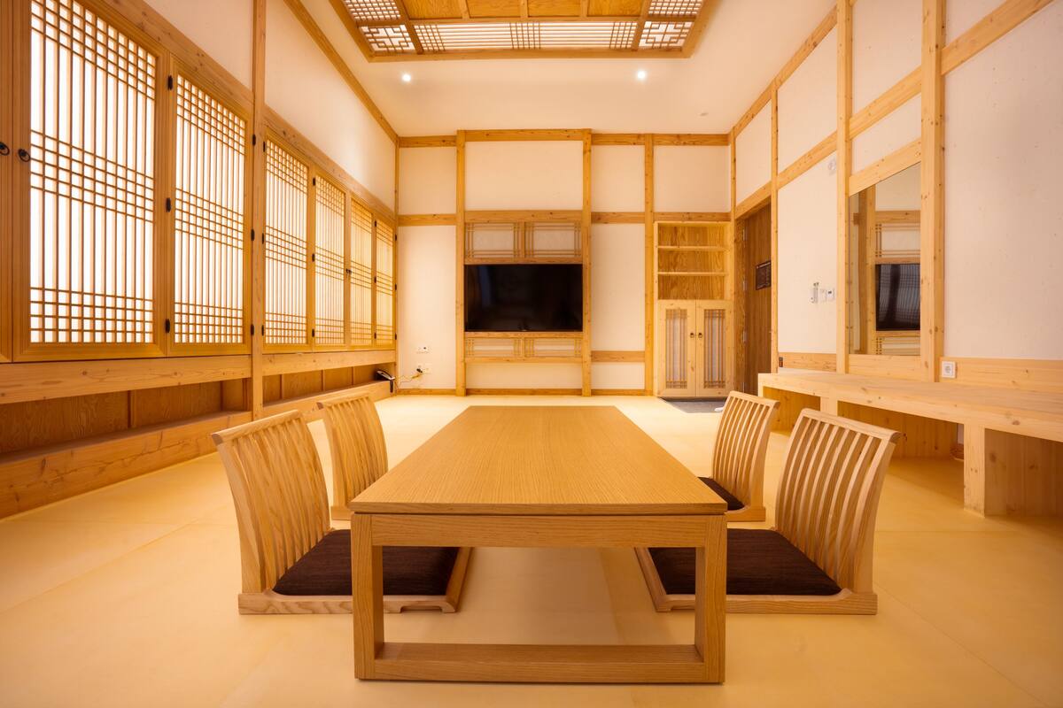 Una habitación tradicional japonesa con suelo de tatami, una mesa de madera baja y asientos integrados.