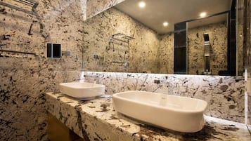 Un baño con encimera de mármol, dos lavabos y un espejo grande.