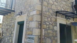 Un bâtiment en pierre sur lequel on peut lire l’inscription : « ONEIRO RESIDENCE ».