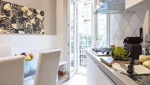 Eine moderne Küche mit einem Gasherd, einer Kaffeemaschine und Blick ins Freie.