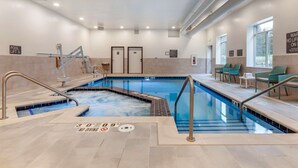 An indoor swimming pool with clear signage, a lifeguard stand, and a seating area with chairs. - Comfort Suites Cottage Grove – Madison (Cottage Grove)