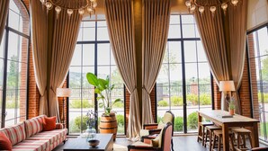 A room with a large window, a sofa, a table, and chairs. - Bengodi Boutique Hotel (Eceabat)