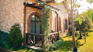 A stone building with arched windows and a wooden deck. - Bengodi Boutique Hotel (Eceabat)