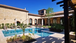 A pool area with stone walls, outdoor seating, and a clear blue sky. - Bengodi Boutique Hotel (Eceabat)