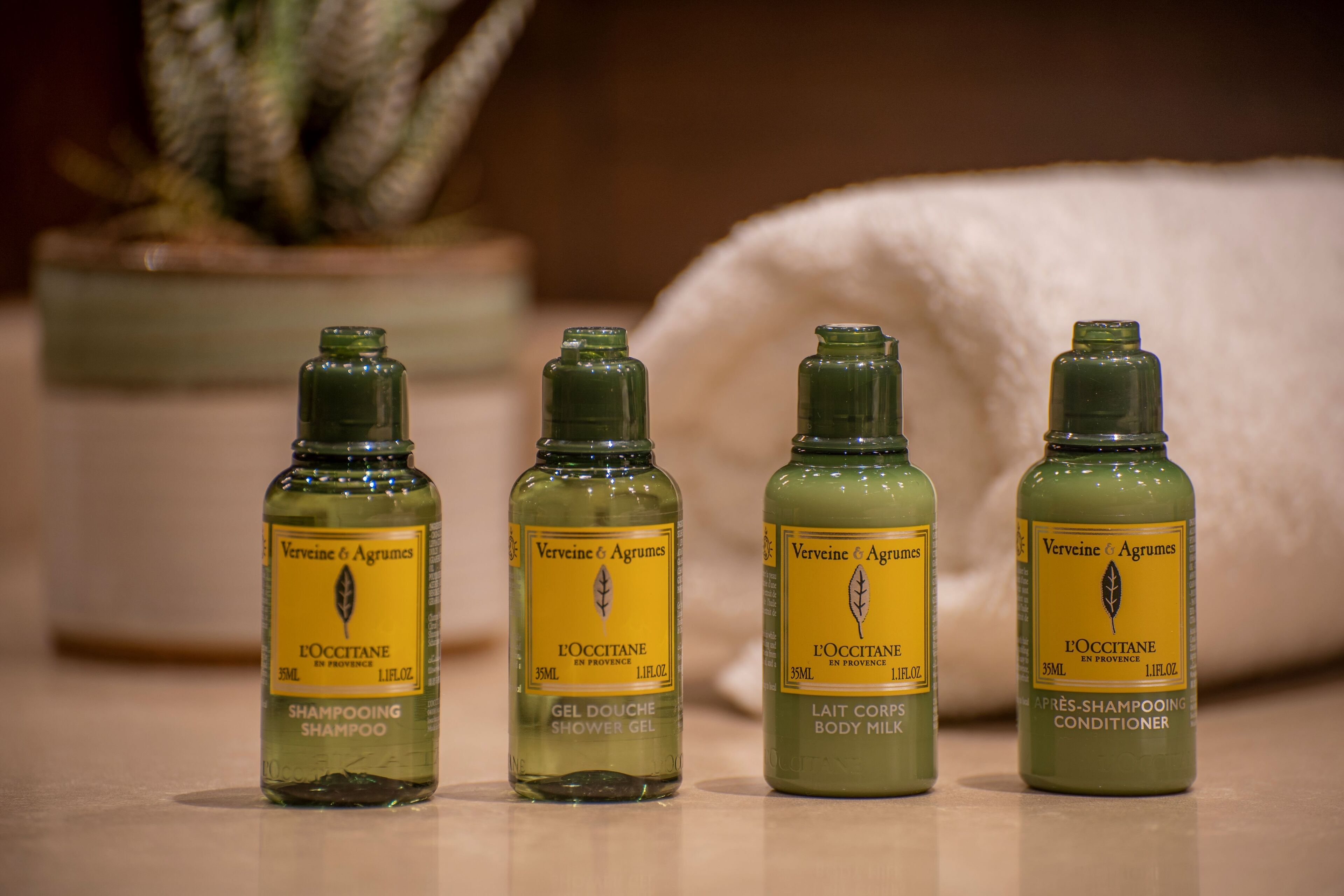 Four bottles of L'OCCITANE products on a table.