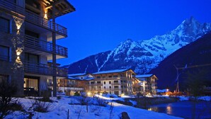 A multi-story hotel with balconies and a view of snow-covered mountains. - La Cordee 221 Penthouse -  sleeps 8 guests with pool, sauna, gym, parking (Chamonix-Mont-Blanc)