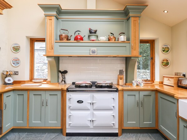 A kitchen with a stove, cabinets, and a window.