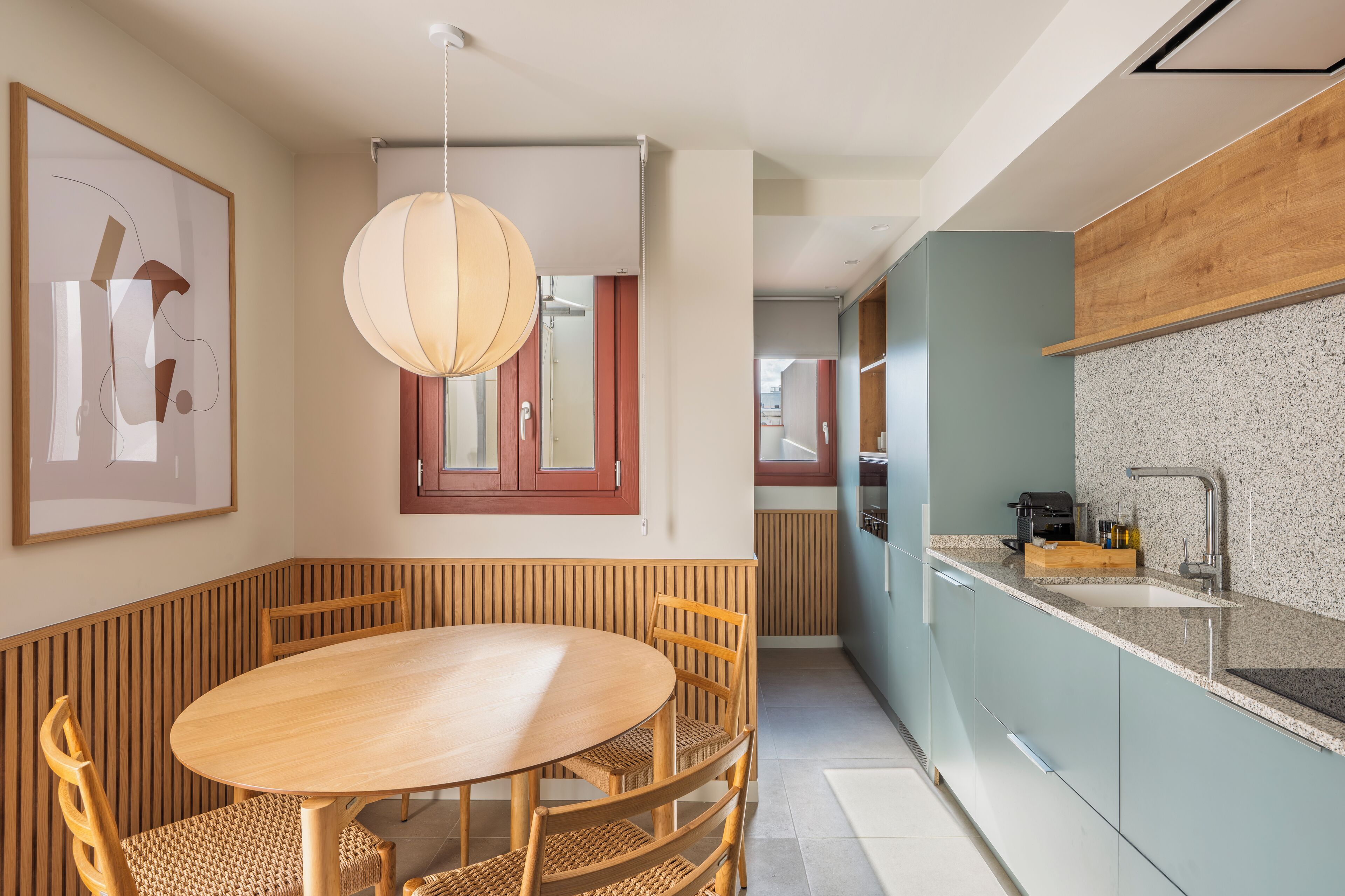 Una cocina moderna con encimera de granito, armarios de madera y horno empotrado.