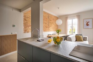 Una cocina moderna con encimera de granito, horno empotrado y pared de ladrillo.