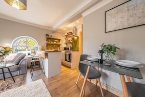 A modern kitchen with a central island, wooden cabinets, and a dining area with a table and chairs.