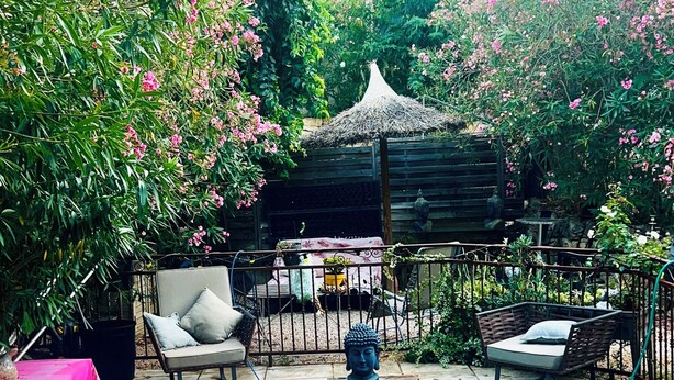 A swimming pool surrounded by lush greenery and a gazebo. - Charming artist's house. (Nîmes)